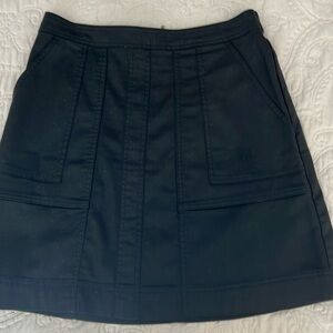 Black everyday miniskirt with stretch, details on front pockets